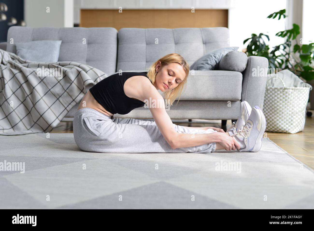 Woman doing stretching exercise at home Stock Photo