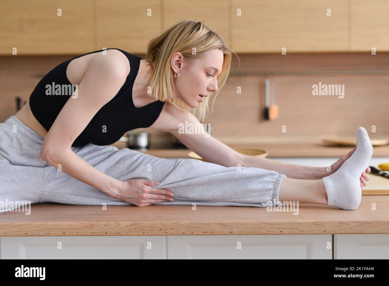 Woman sitting on table doing stretching. Stock Photo