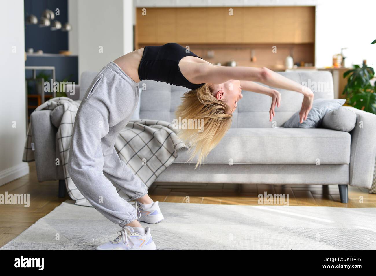 Woman performs bridge exercise at home Stock Photo
