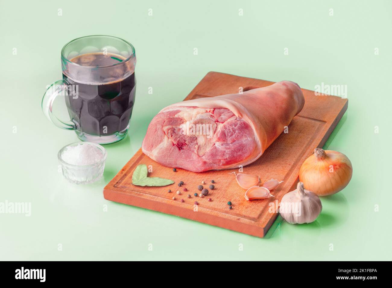 Raw Pork knuckle, dark beer and other ingredients for cooking baked