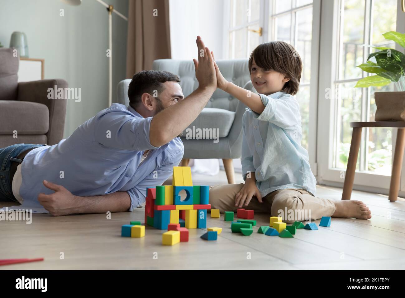 Happy proud dad and cheerful little son boy clapping hands Stock Photo