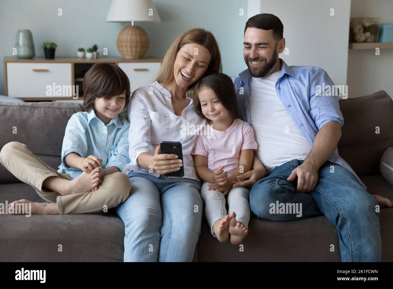 Happy family taking selfie on home couch Stock Photo
