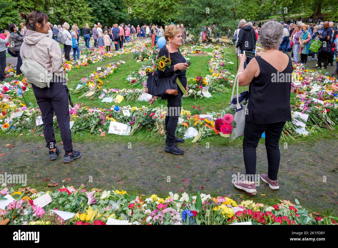 Her Majesty Queen Elizabeth floral tributes- People are pictured as they view the flowers and cards that have been left in Green Park, London Stock Photo