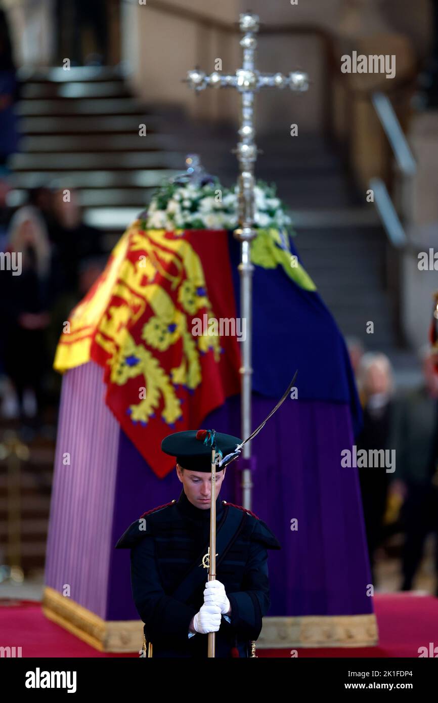 A King's Bodyguard from the Royal Company of Archers stands guard as members of the public view the coffin of Queen Elizabeth II, lying in state on the catafalque in Westminster Hall, at the Palace of Westminster, London, ahead of her funeral on Monday. Picture date: Sunday September 18, 2022. Stock Photo