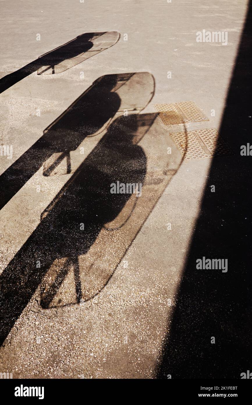 A couple of phone booth shadows on the ground captured during daylight ...