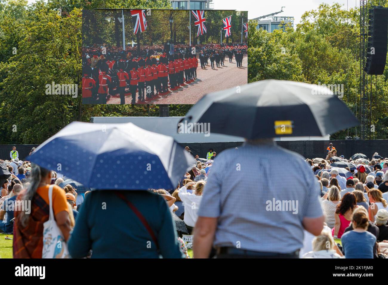 Crowds in Hyde Park are pictured watching Her Majesty the Queen's coffin being transported to the Palace of Westminster on large video screens. Stock Photo