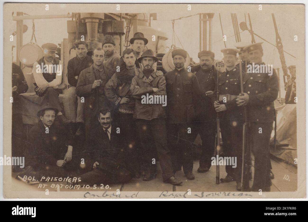 'Bolshevik prisoners at Batoum 10.5.20': photograph of Bolshevik or Communist prisoners on board British Navy battleship HMS Royal Sovereign in May 1920. British servicemen (Royal Marines?) are standing next to the prisoners with fixed bayonets. The HMS Royal Sovereign was at Batoum (now Batumi in Georgia) as part of British involvement in the Russian Civil War following the 1917 Bolshevik Revolution. The prisoners are in a range of clothing - from leather jackets to an embroidered traditional style shirt Stock Photo