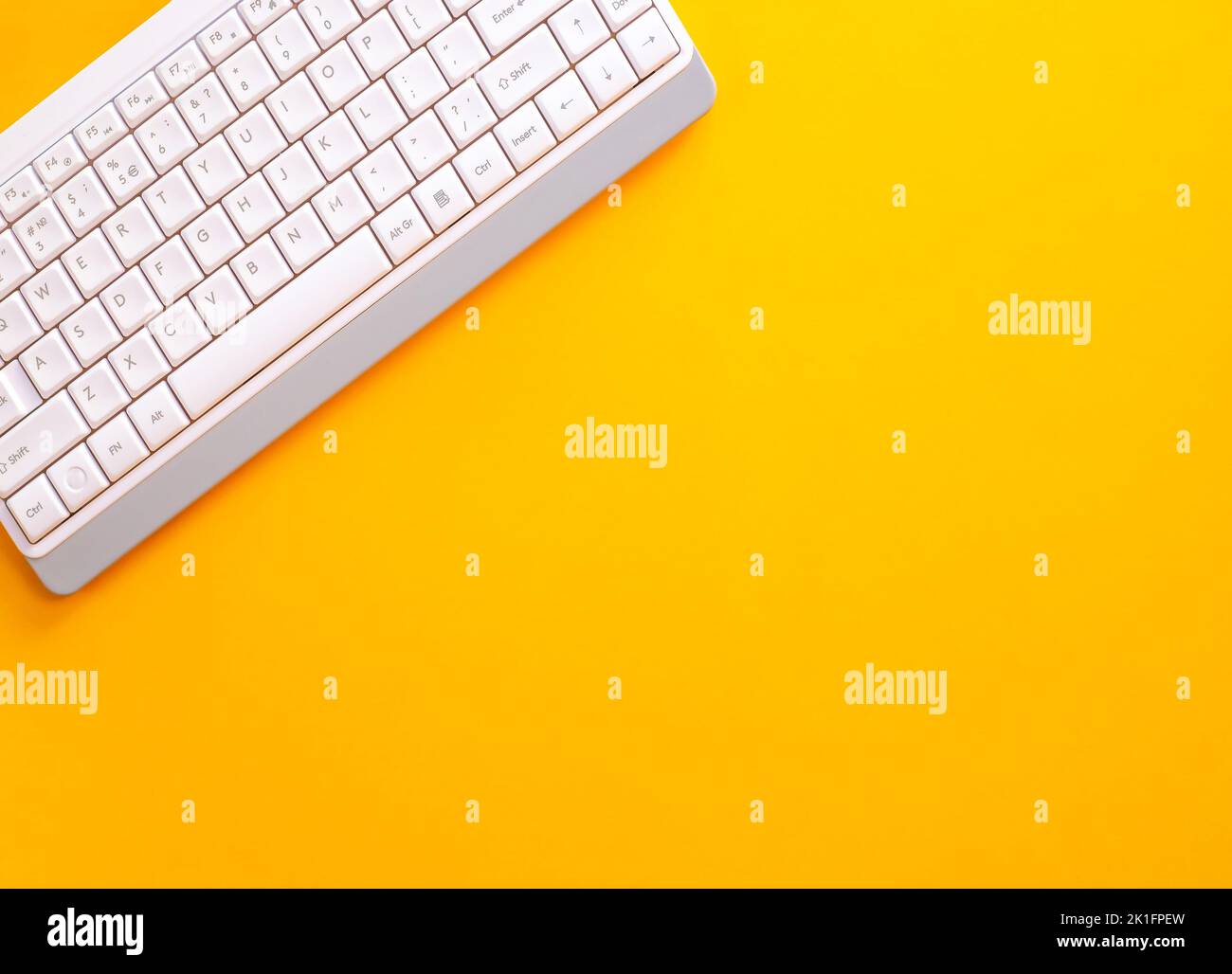 Modern white keyboard on yellow background, great design for any purpose. Flat PC symbol. Top view, copy space Stock Photo