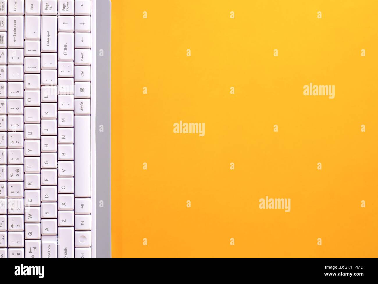 Modern white keyboard on yellow background, great design for any purpose. Flat PC symbol. Top view, copy space. vertical arrangement Stock Photo