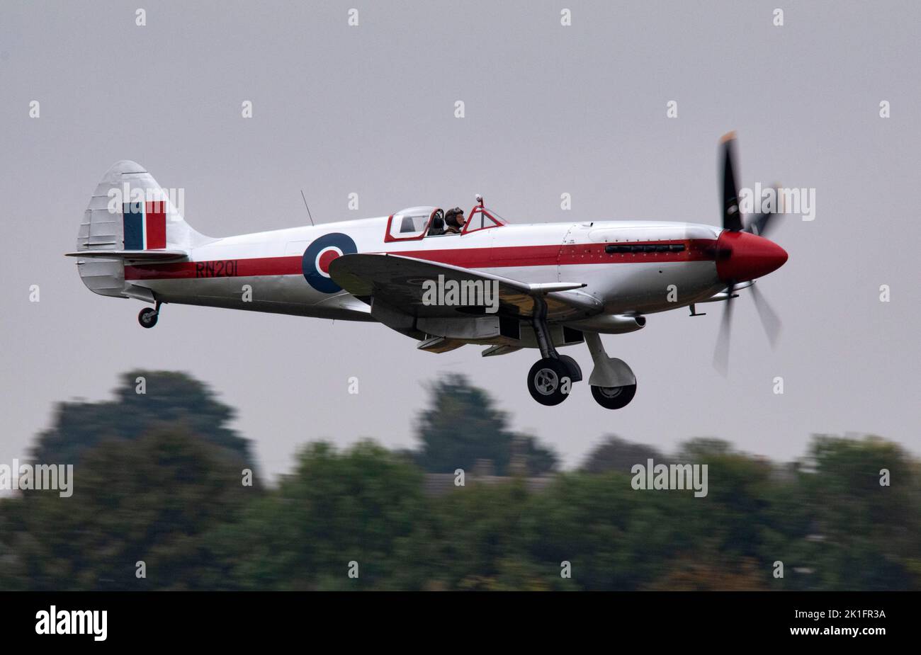 Supermarine Spitfire Mk.XIVe RN201 (G-BSKP) landing at dusk, after it's flying display at the IWM Duxford Battle of Britain Air show10th September 22 Stock Photo