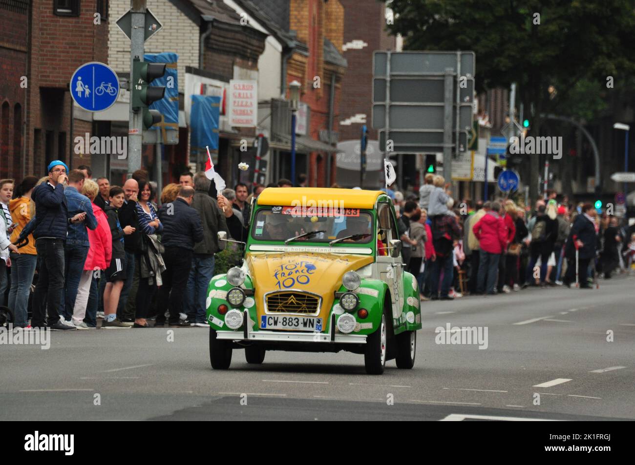 A cute green and yellow Citroen 2CV at the 2017 Tour de France in Meerbusch, Germany with spectators around it Stock Photo
