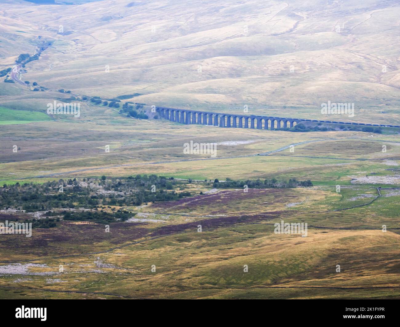 Looking down on the Ribblehead viaduct on the Settle, Carlisle line with a train crossing, from Ingleborough, Yorkshire Dales, UK. Stock Photo