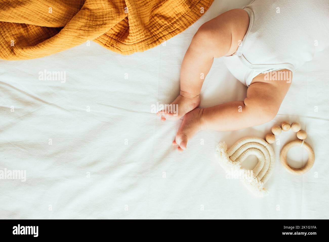 Baby playing with a wooden toy. Top view. Copy space. Stock Photo