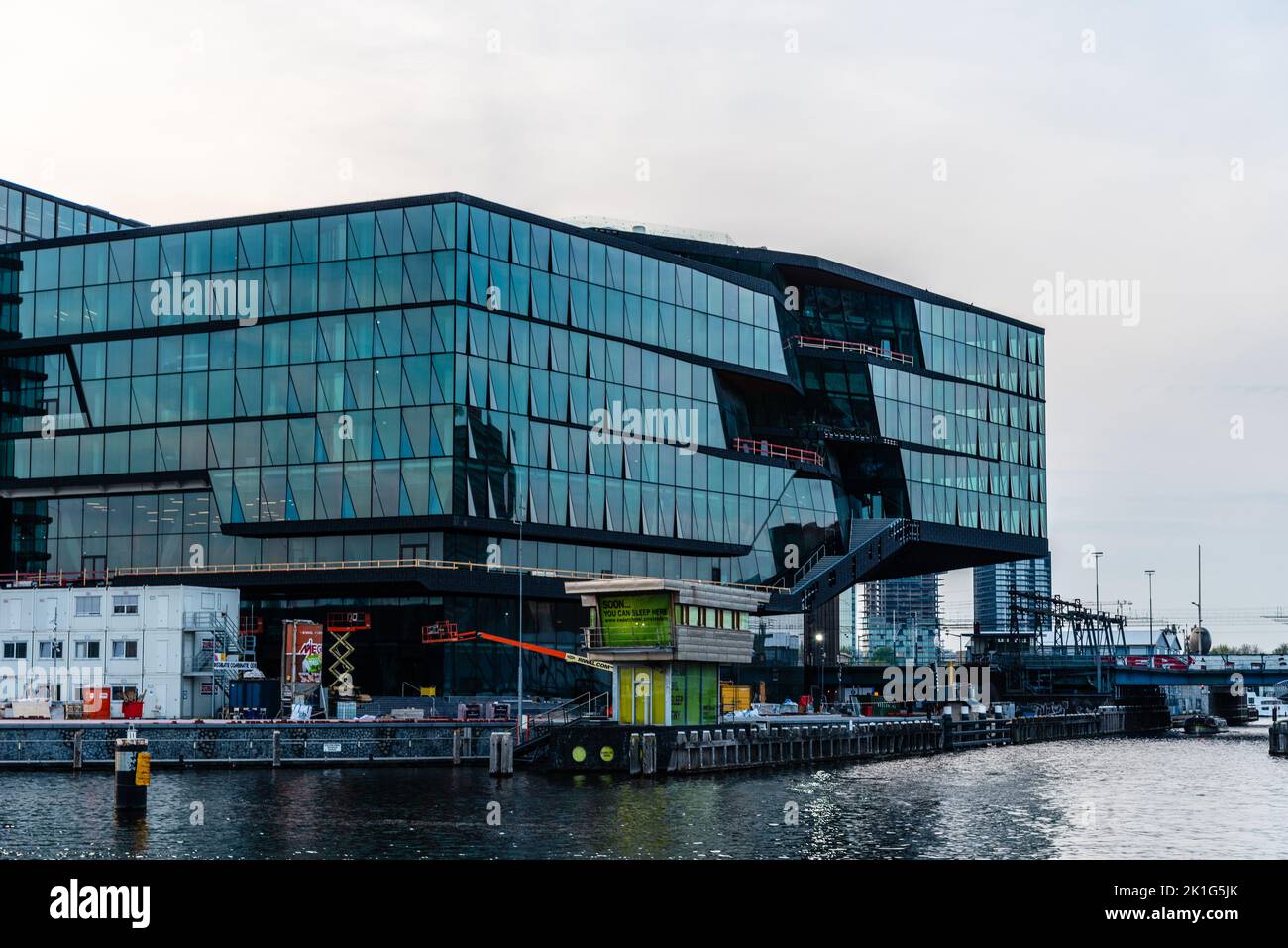 Amsterdam, Netherlands - May 6, 2022: View of the waterfront of the canal with new luxury residential and commercial developments Stock Photo