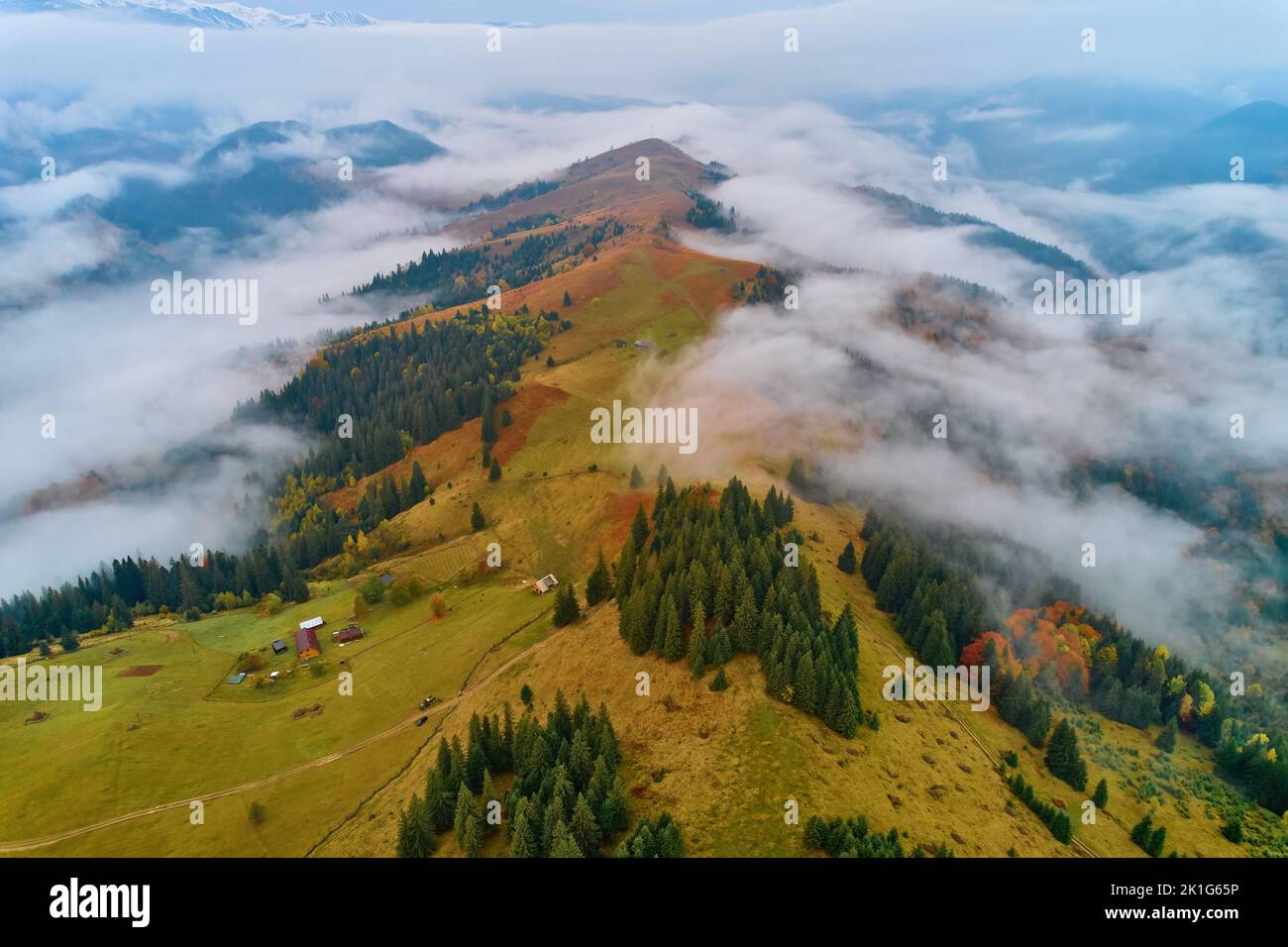 Mountains in clouds at sunrise in summer. Aerial view of mountain peak ...