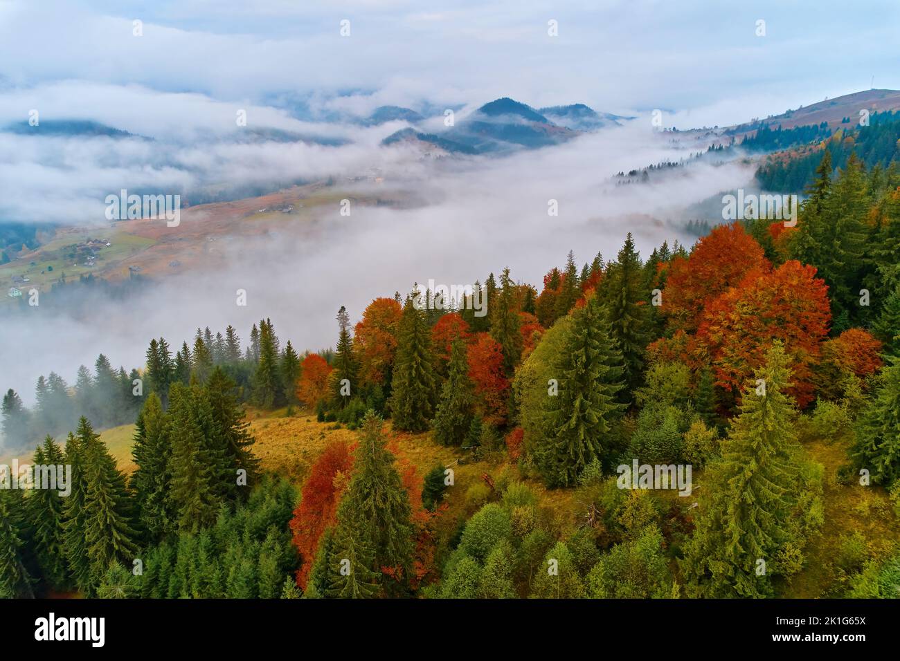 Mountains in clouds at sunrise in summer. Aerial view of mountain peak ...