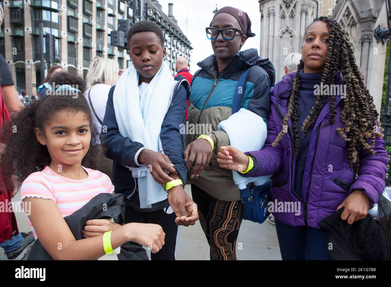 London, UK, 18 September 2022: A family show their wristbands from the queue after they have filed past Queen Elizbeth II's coffin in Westminster Hall. The queue for admission to Westminster Hall has now closed in order for all of those already in the queue to pass through before 6.30am tomorrow morning. Anna Watson/Alamy Live News Stock Photo