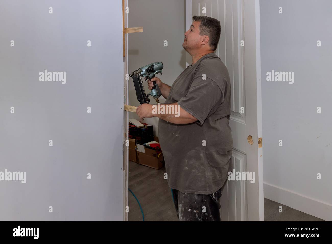 The interior doors of a new house are being installed by a carpenter trim worker Stock Photo