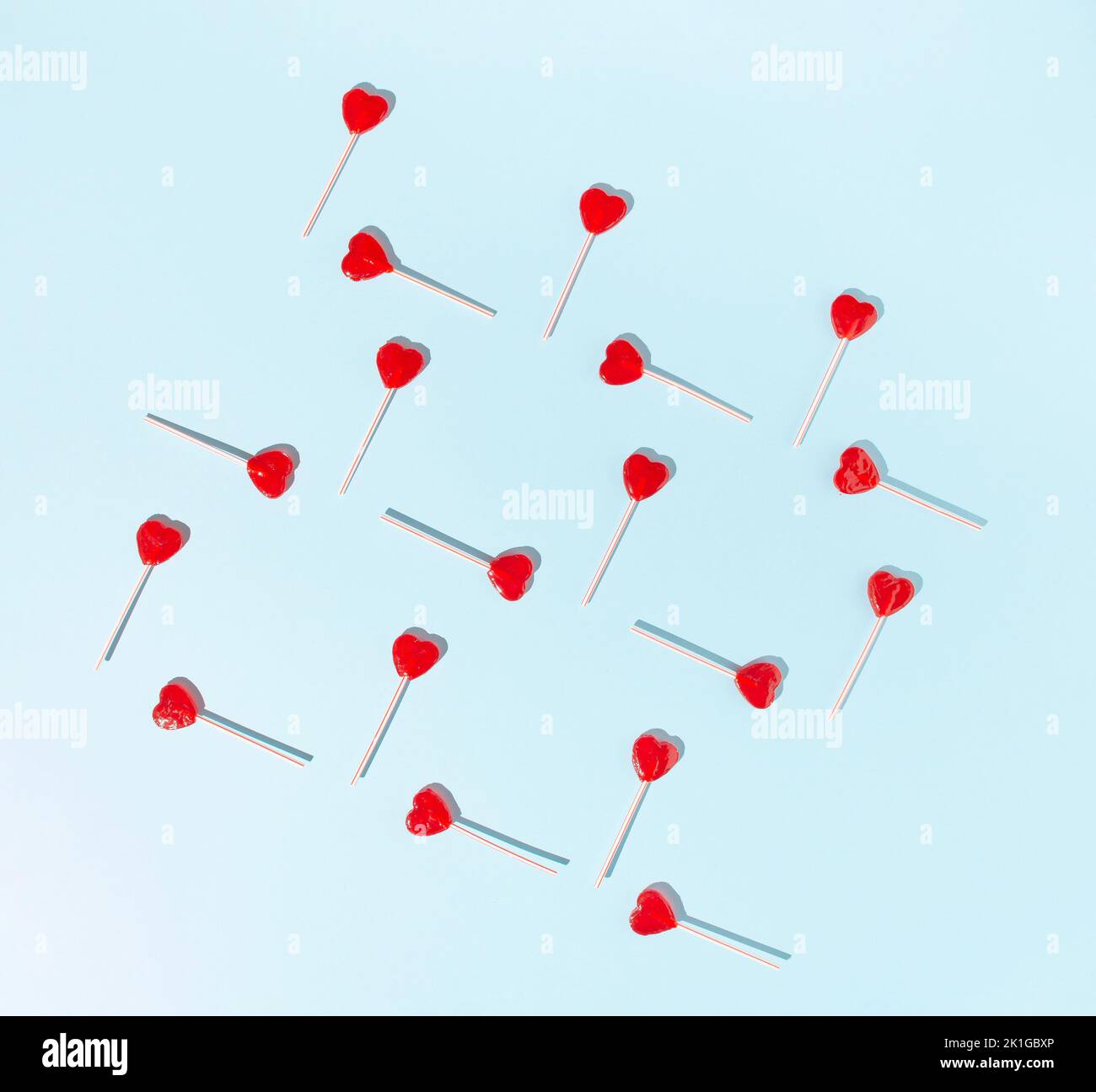 Red heart lollipops on a pale blue background. Minimal concept Stock