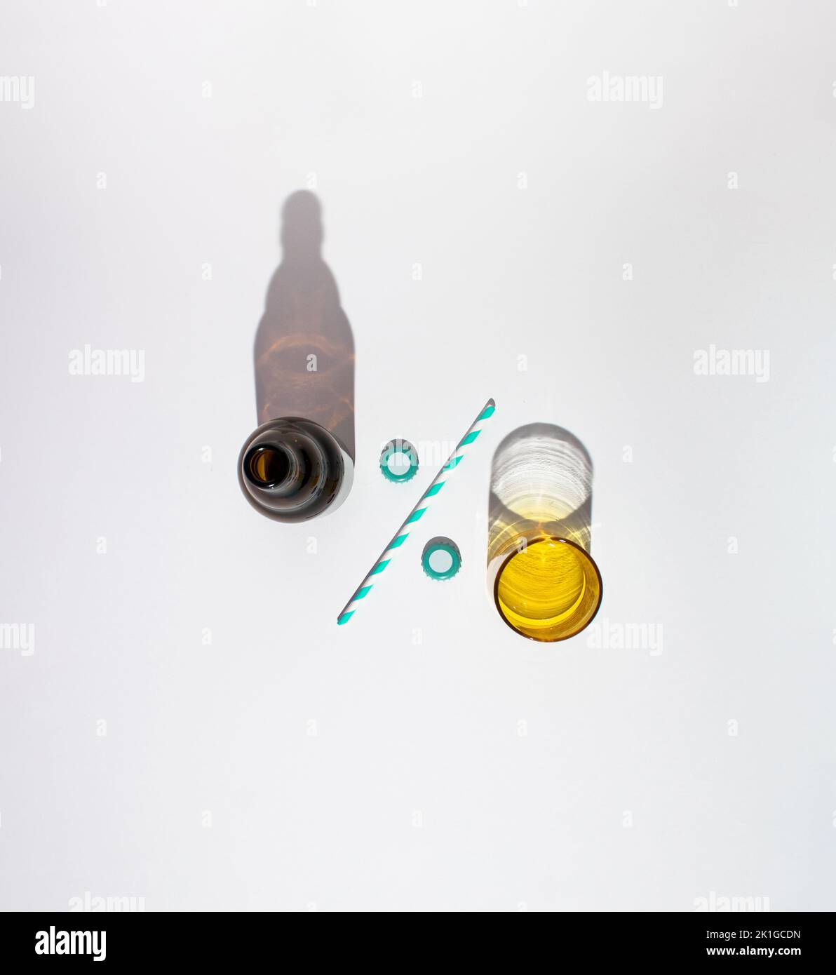 Beer bottle and glass with drinking straw and bottle caps formed as