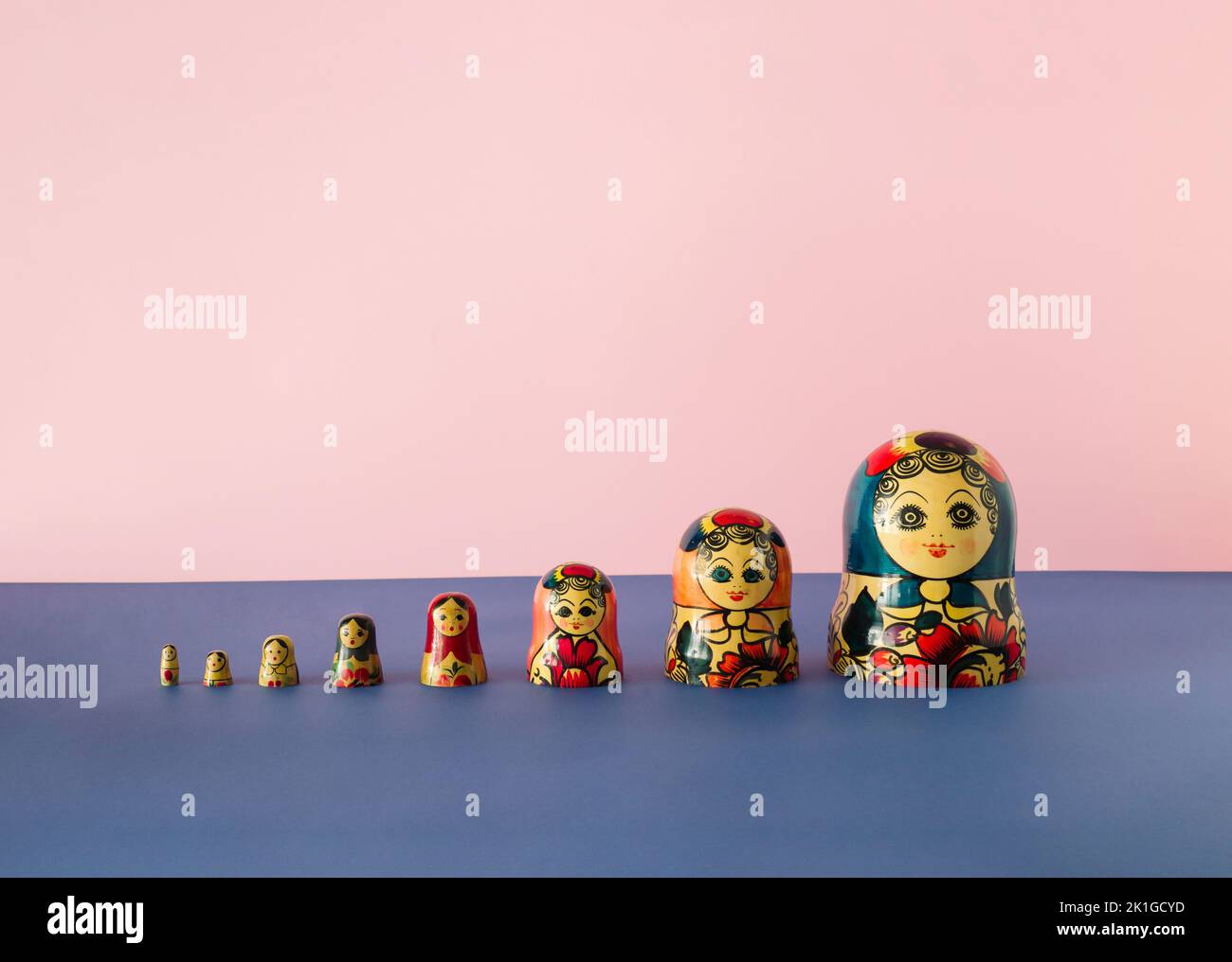 Russian dolls also known as matryoshka or babushka stacked on a pink and blue background. Minimal concept. Stock Photo
