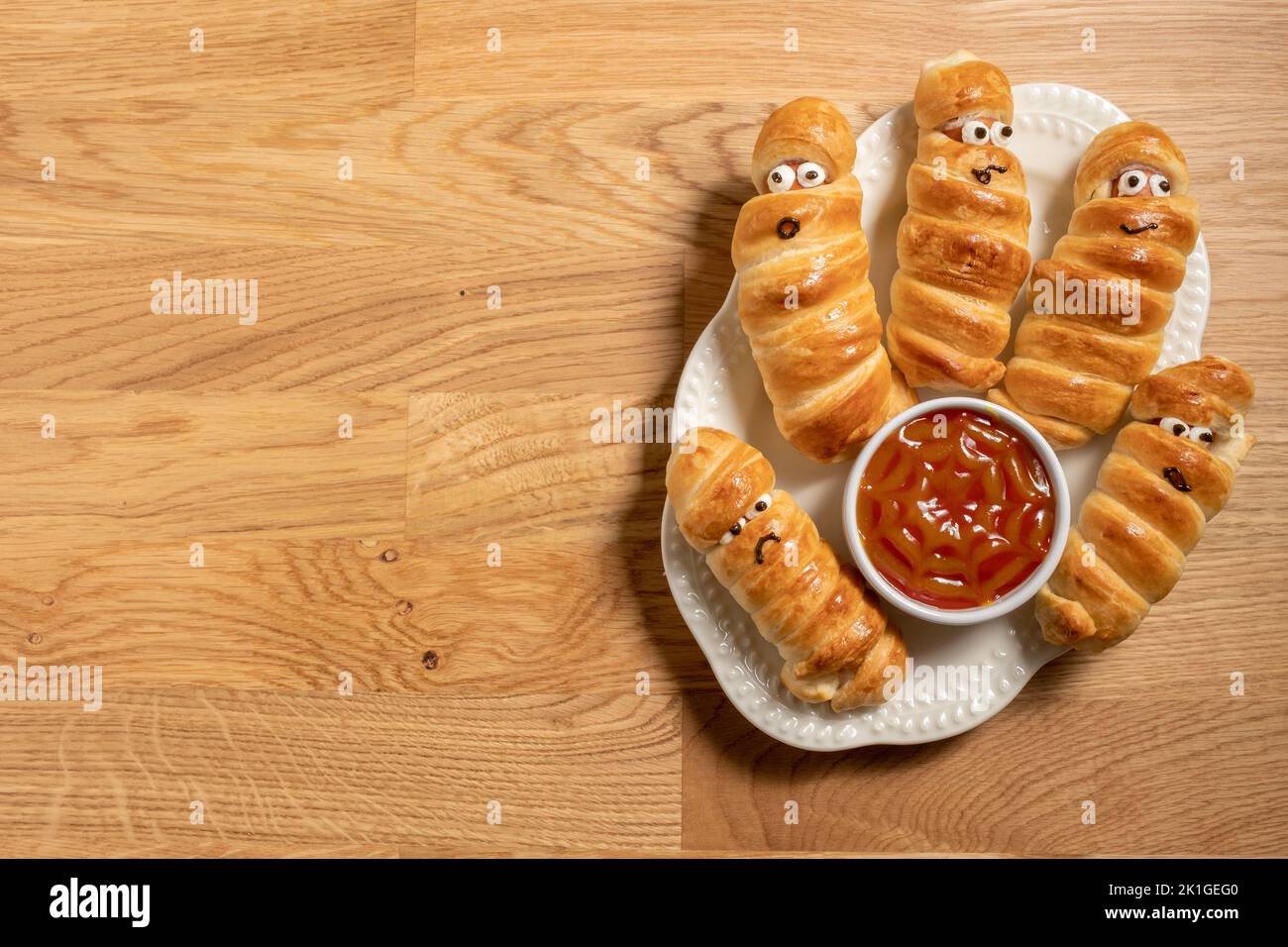 Mummy sausages scary halloween party food decoration wrapped in dough Stock Photo