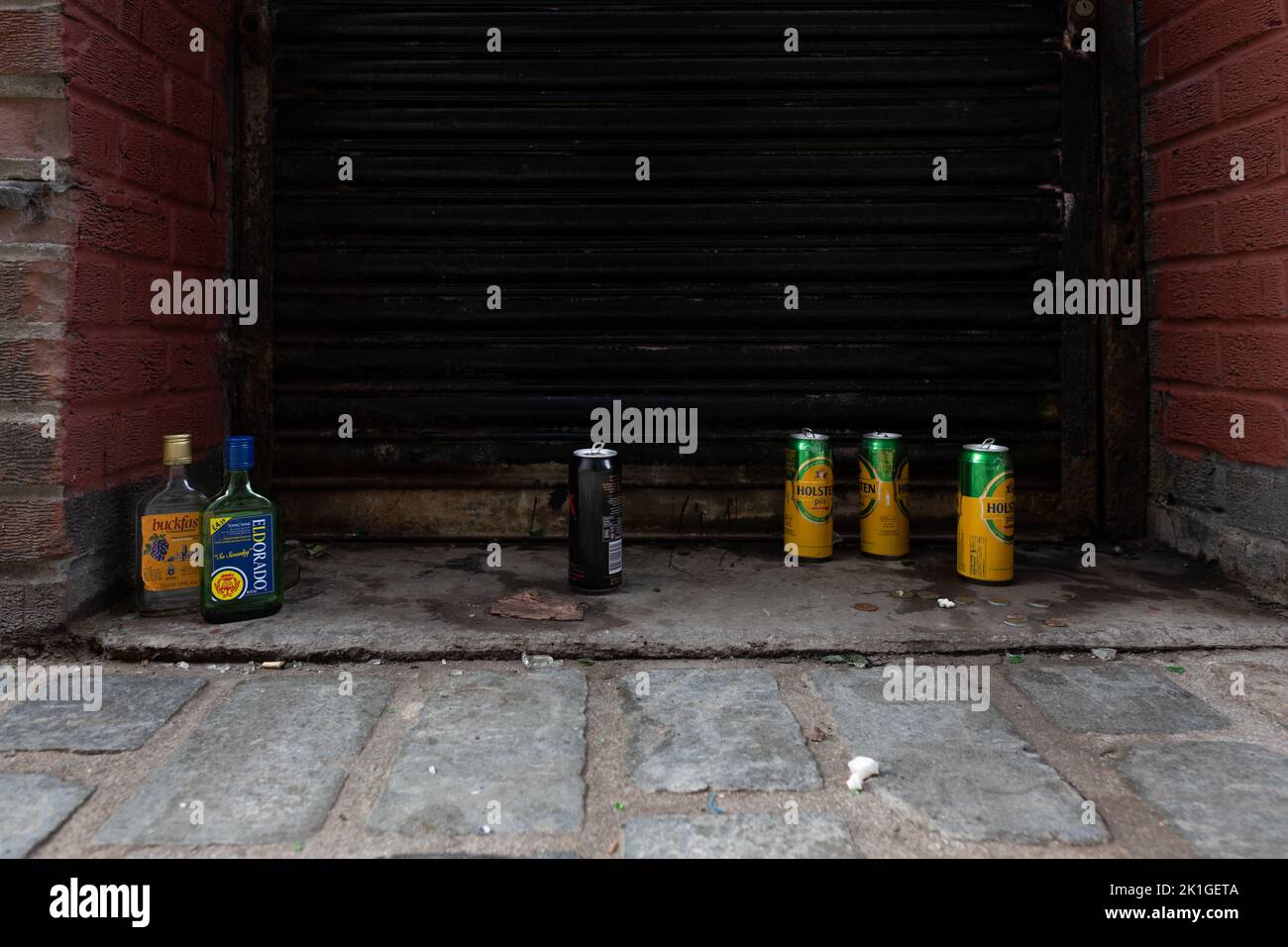 Alcohol Scotland - Empty buckfast, Eldorado, cider and Holsten Pils lager cans in back alley doorway, Glasgow city centre, Scotland, UK Stock Photo