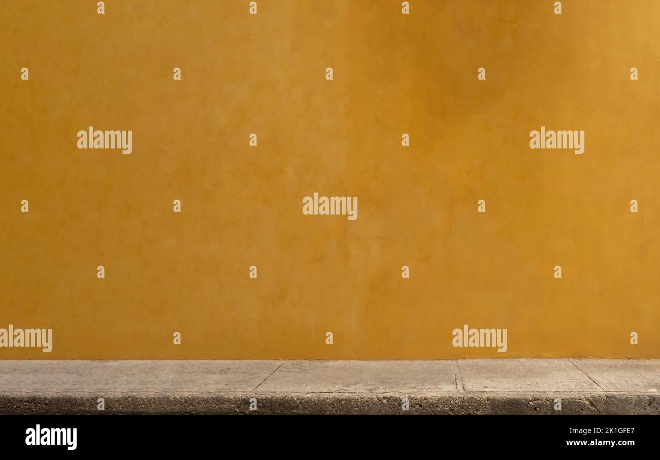 Colorful yellow wall of caribbean house with stucco texture for background. Minimal exterior space. Stock Photo