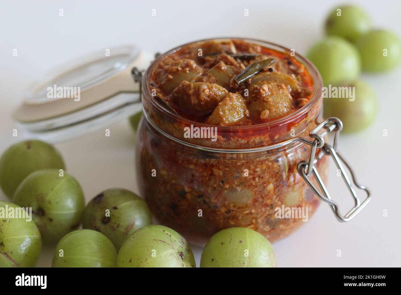 Amla Pickle or gooseberry pickle stored in a glass bottle. It is a spicy condiment made with Amla also known as Indian gooseberries, red chilli powder Stock Photo