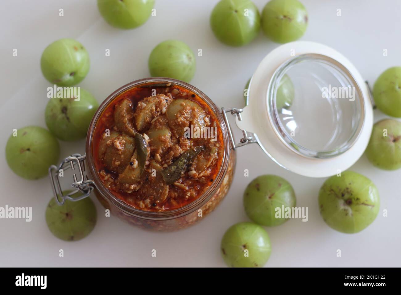 Amla Pickle or gooseberry pickle stored in a glass bottle. It is a spicy condiment made with Amla also known as Indian gooseberries, red chilli powder Stock Photo