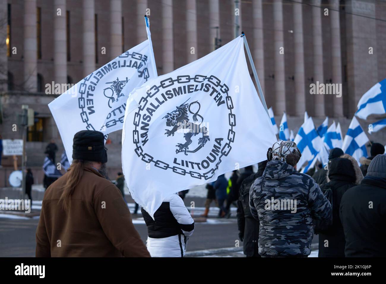 Helsinki, Finland - December 6, 2021: Demonstrators carrying Kansallismielisten liittouma (Nationalists alliance) flags at the far-right ethnonational Stock Photo