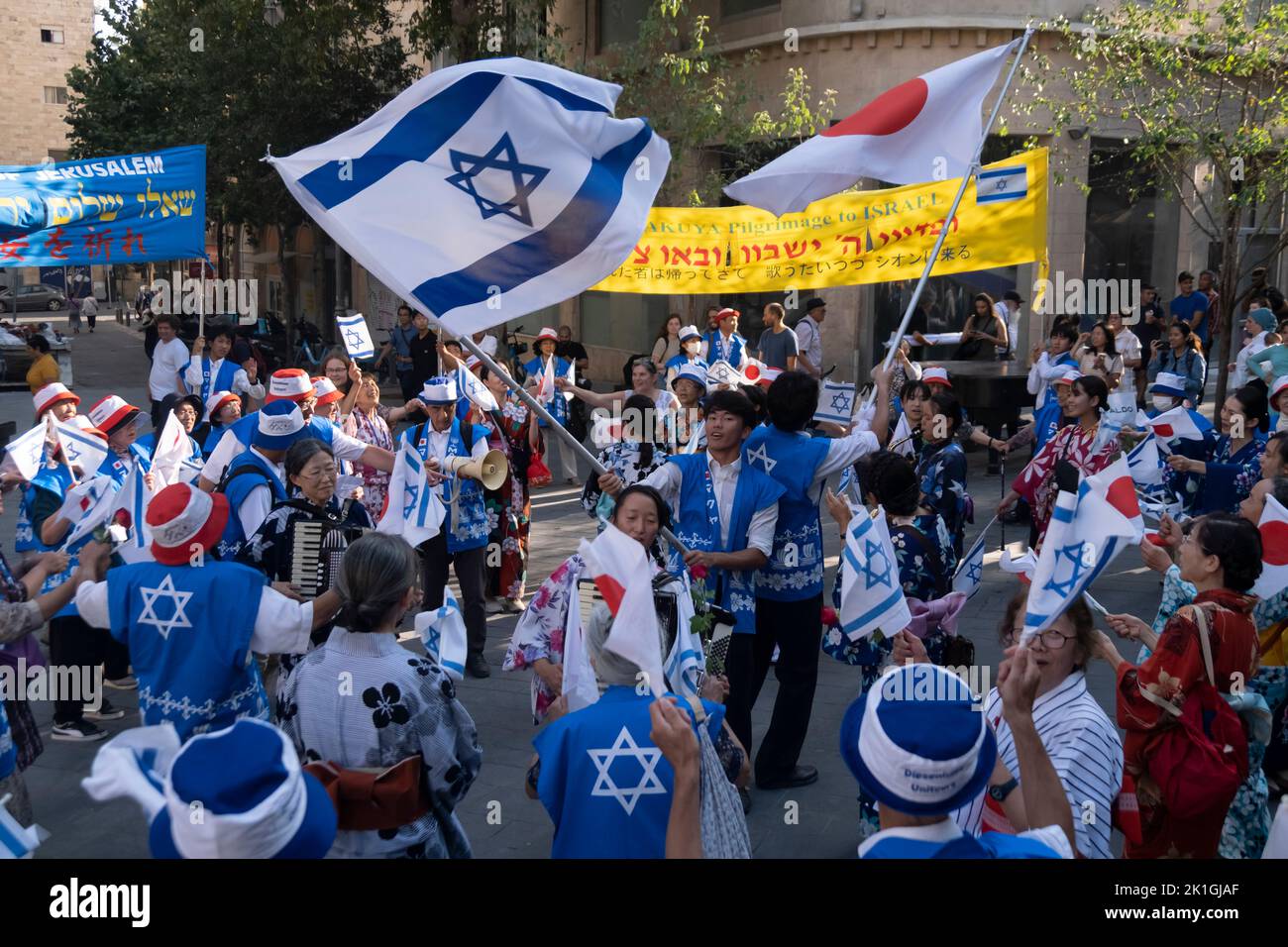 Members of the Japanese Makuya movement dance with the national flags of Israel and Japan in Zion Square on September 18, 2022 in downtown Jerusalem, Israel. The Makuya movement is a religious movement which was founded in 1948 in Japan, Its members are passionate supporters of Israel and consider the establishment of the Jewish state and the unification of Jerusalem 19 years later to be the fulfillment of biblical prophecies. Stock Photo