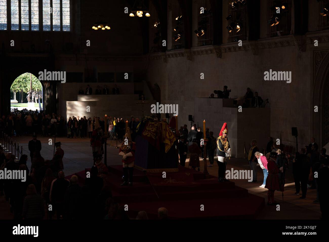 Members of the public file past the coffin of Queen Elizabeth II, draped in the Royal Standard with the Imperial State Crown and the Sovereign's orb and sceptre, lying in state on the catafalque in Westminster Hall, at the Palace of Westminster, London. Picture date: Sunday September 18, 2022. Stock Photo