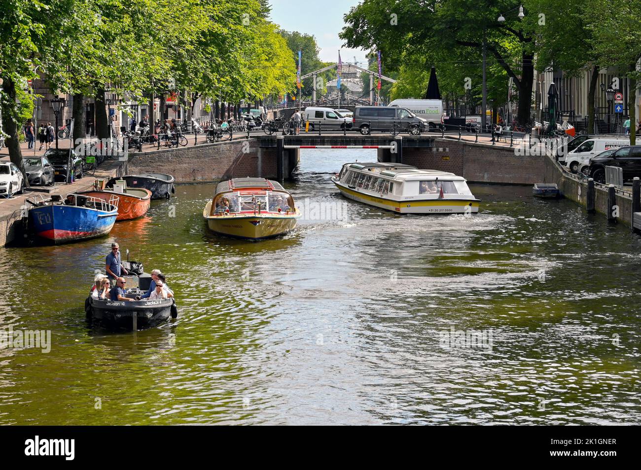 Amsterdam, Netherlands - August 2022: Small motor boat and sightseeing boats on a canal in the city centre Stock Photo