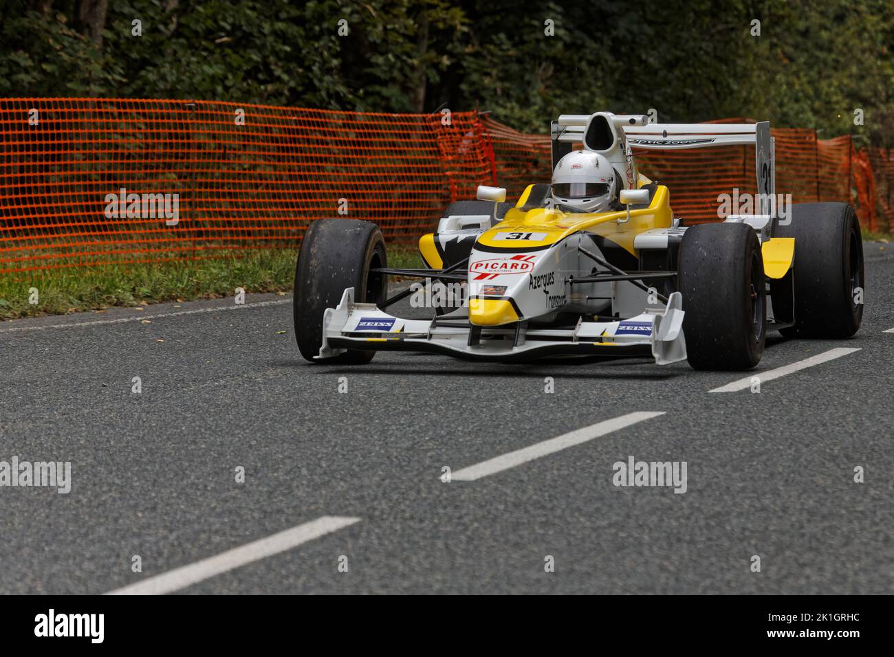 LIMONEST, FRANCE, September 17, 2022 : Racing Car drives slowly on an open road to the paddock of the annual uphill car race. Stock Photo