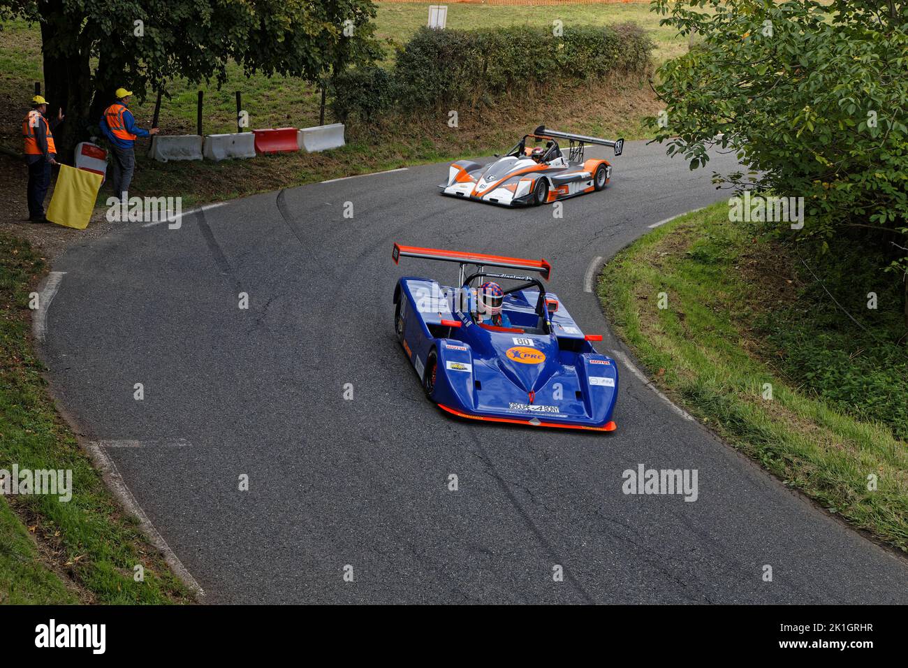 LIMONEST, FRANCE, September 17, 2022 : Racing Cars drive slowly on an open road to the paddock of the annual uphill car race. Stock Photo