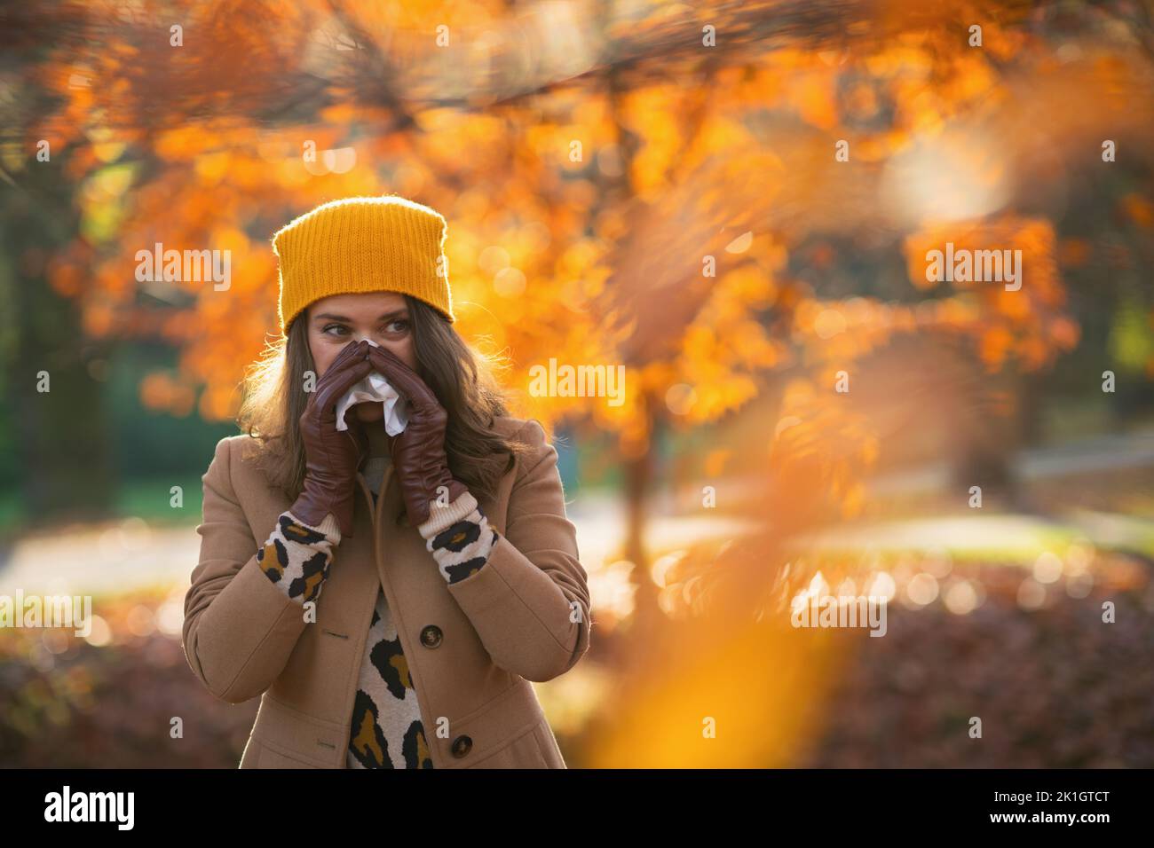 Hello autumn. modern 40 years old woman in brown coat and yellow hat