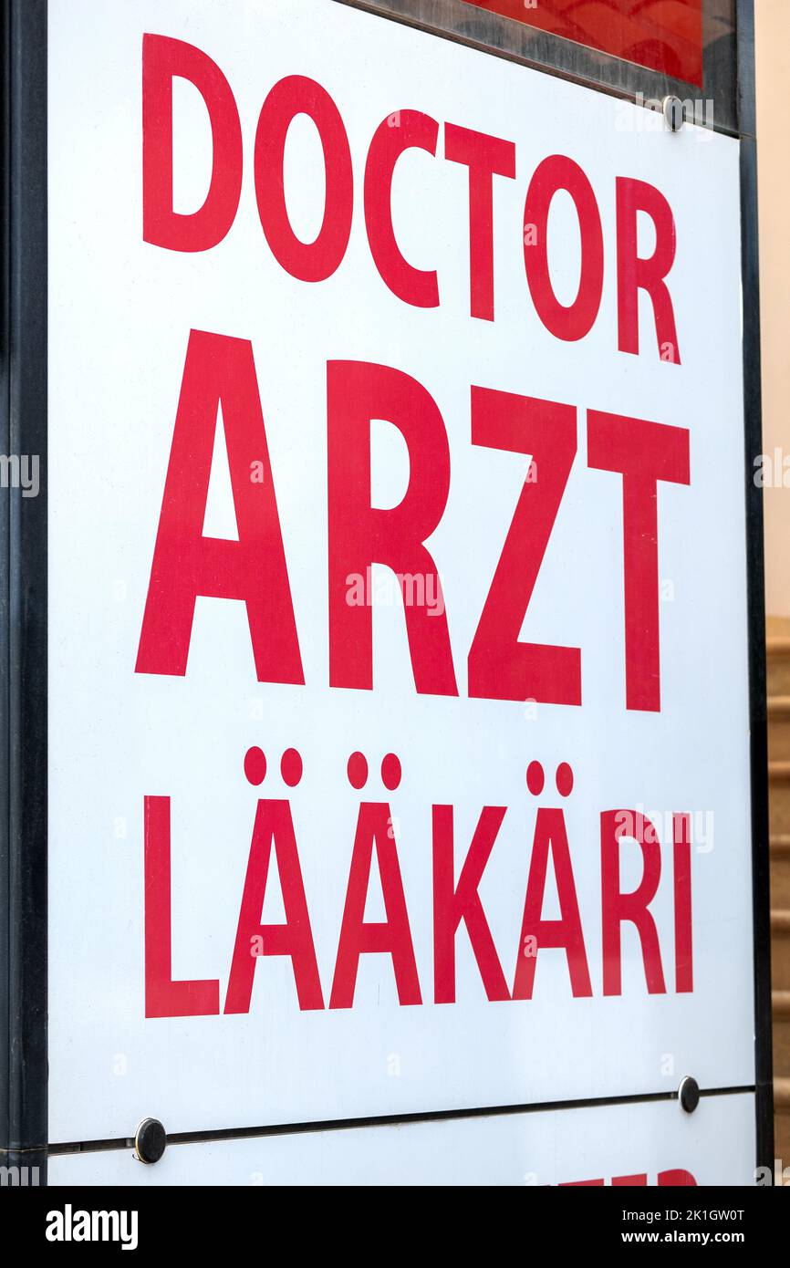 Street sign with red lettering 'doctor' in tourist area. Stock Photo