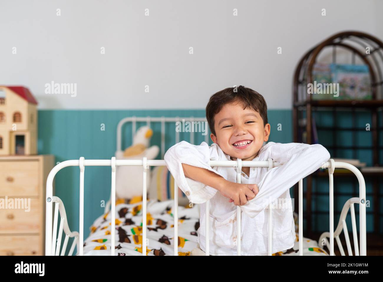 Young cute boy relaxing at his bed while smiling horizontal shot Stock Photo