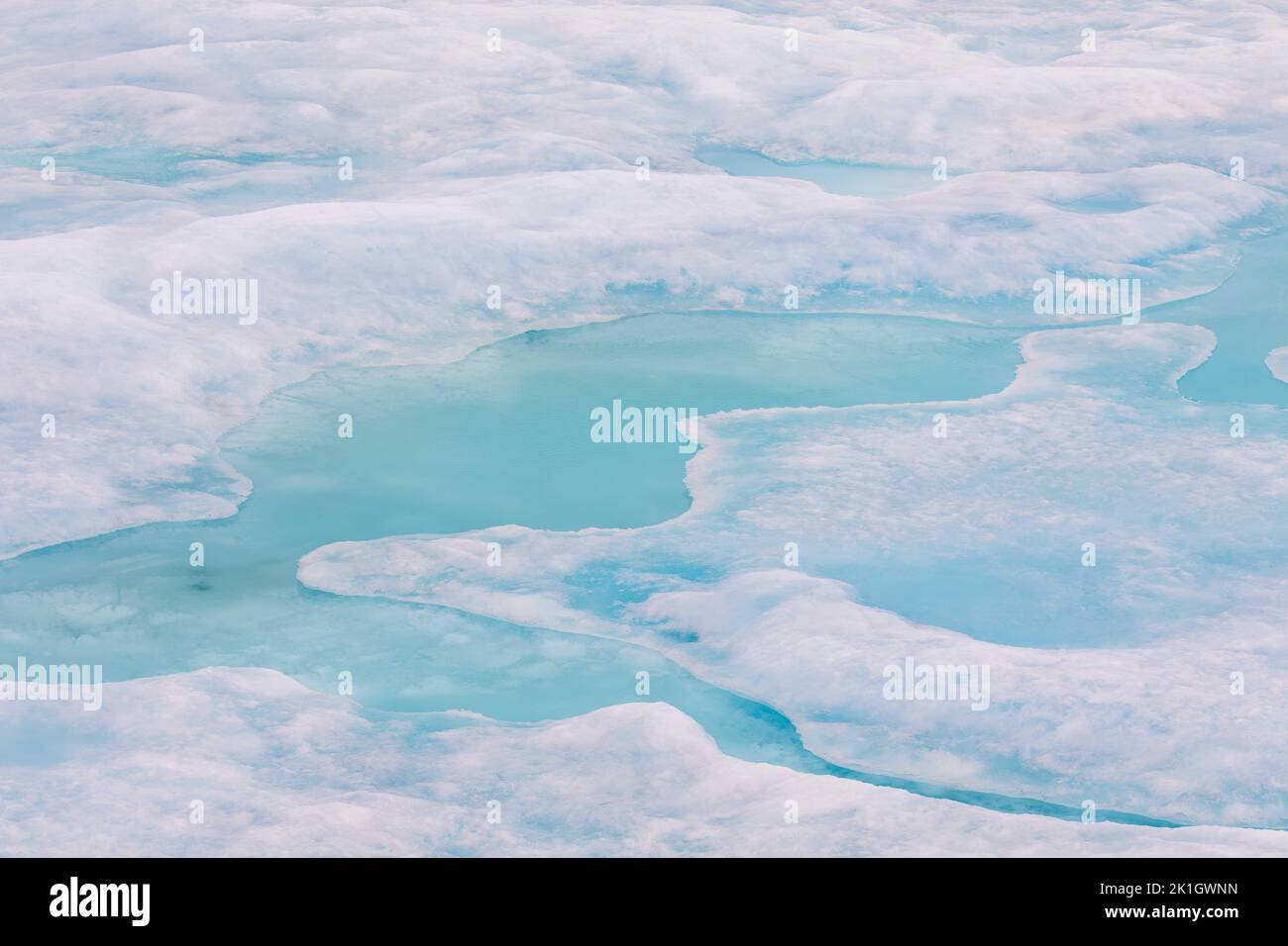 Abstract landscape with pools of aqua water in ice floes of high arctic. Stock Photo