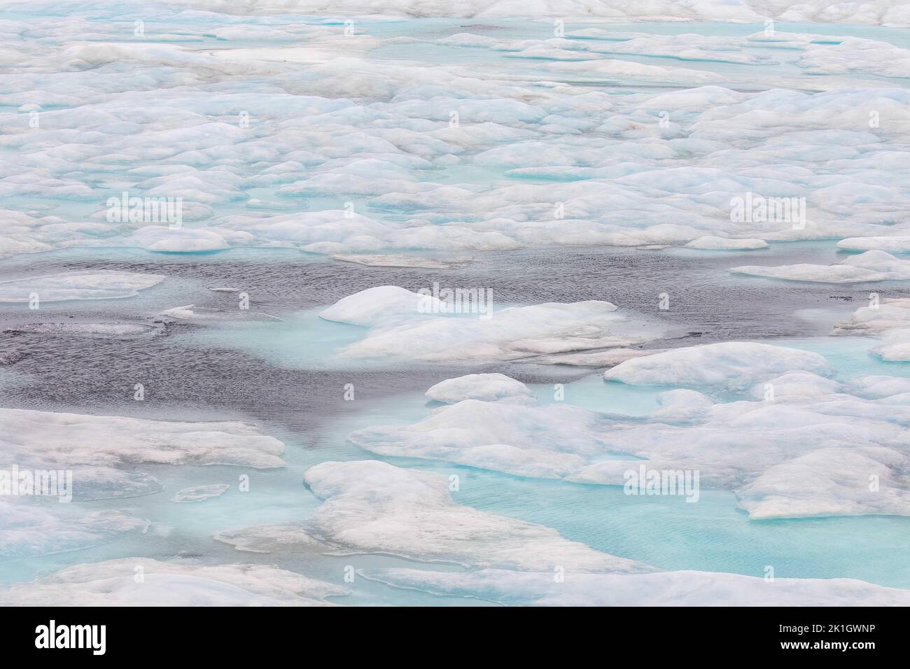 Abstract landscape with pools of aqua water in ice floes of high arctic. Stock Photo