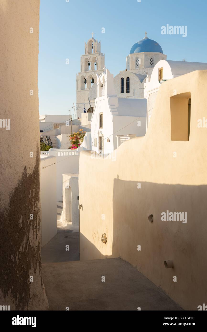 A narrow old town lane in the quaint village of Pyrgos Kallistis leads to the traditional blue dome Greek Orthodox Saint George Church on the island o Stock Photo