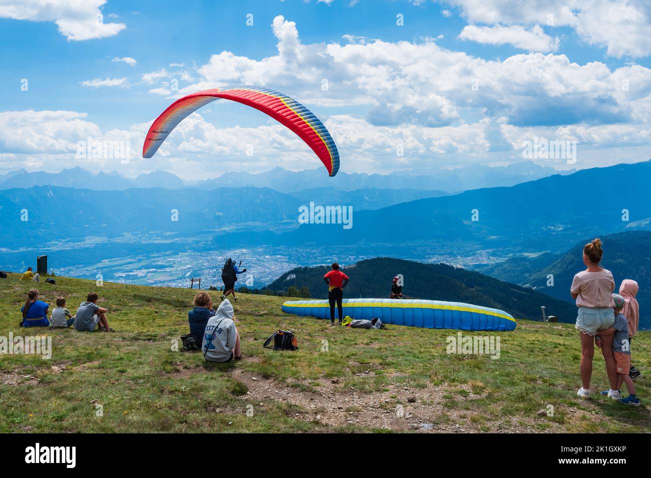 Gerlitzen, Carinthia, Austria - August 01, 2022: People Watching A Paraglider Take Off From The Top Of Gerlitzen Alpe In Austria Stock Photo