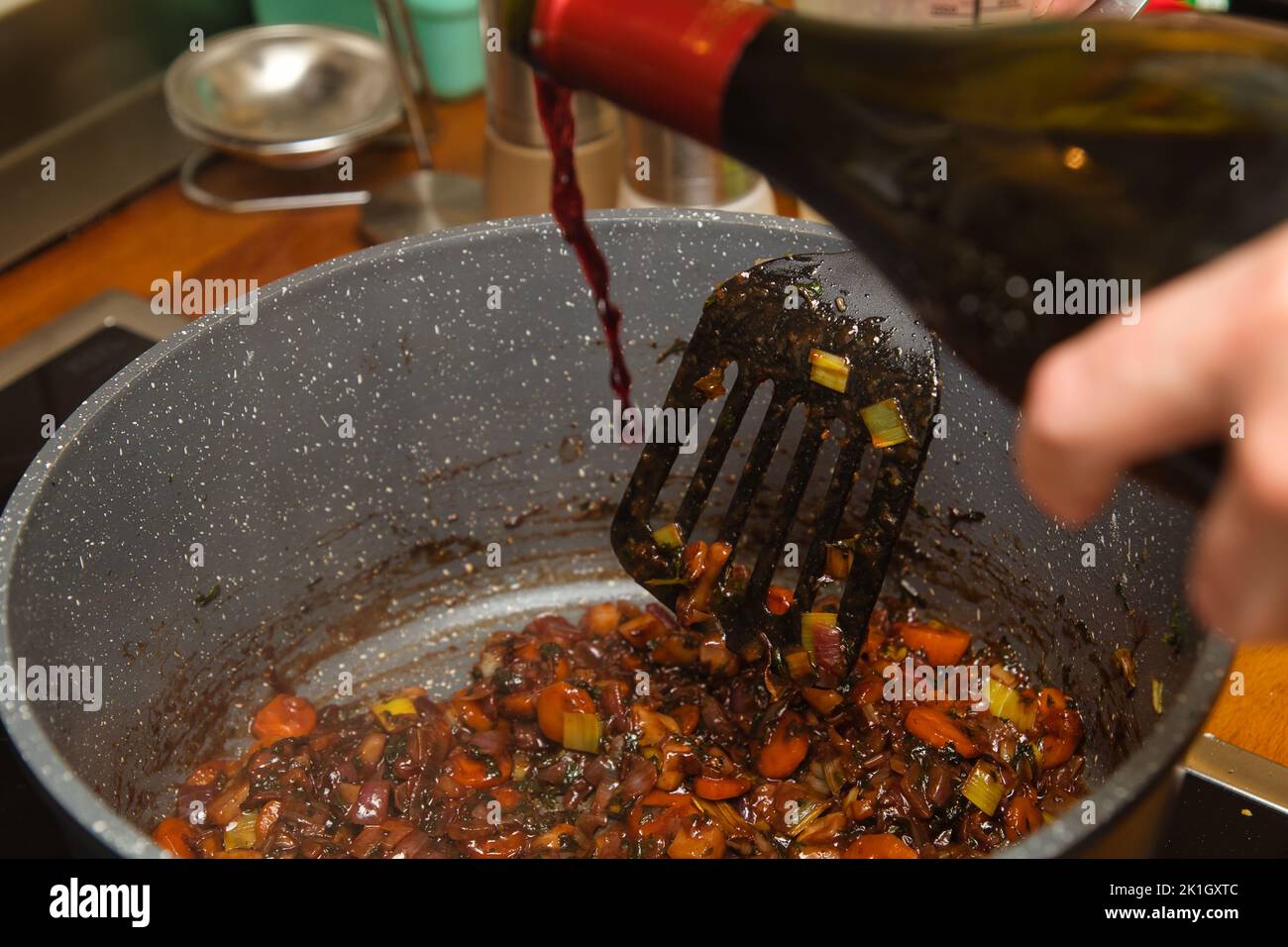 Roast root vegetables for a sauce and deglaze with red wine Stock Photo