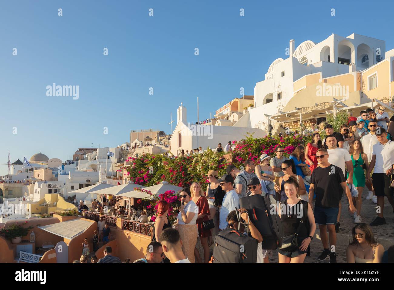 Oia, Greece - September 11, 2022: Narrow, overcrowded and cogested streets in Oia, Santorini filled with a crowd of tourists during summer high season Stock Photo