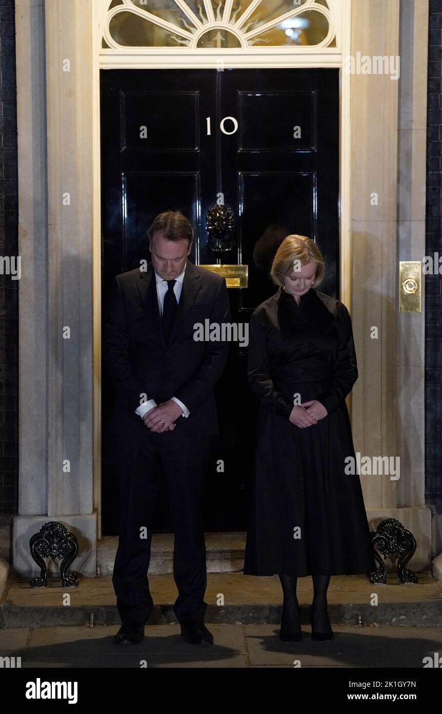 Prime Minister Liz Truss and her husband Hugh O'Leary observe the national minute's silence in memory of Queen Elizabeth II, outside 10 Downing Street, London. The country is observing one-minute silence to remember the Queen, with people invited to mark the occasion privately at home, on their doorstep or street, or at community events and vigils. Picture date: Sunday September 18, 2022. Stock Photo