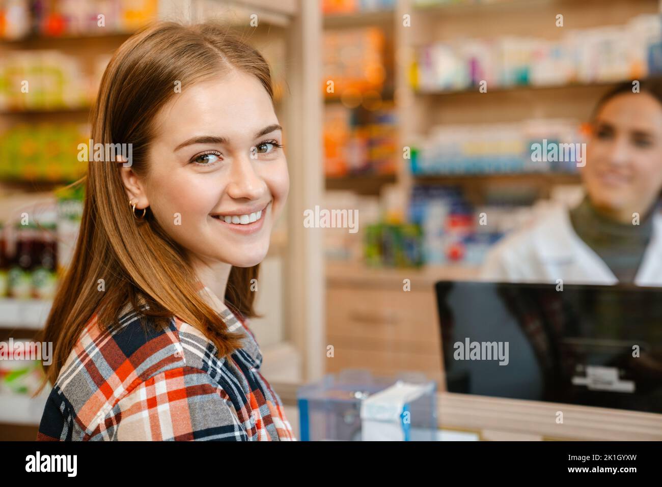 White ginger woman smiling while buying medicine in pharmacy indoors Stock Photo