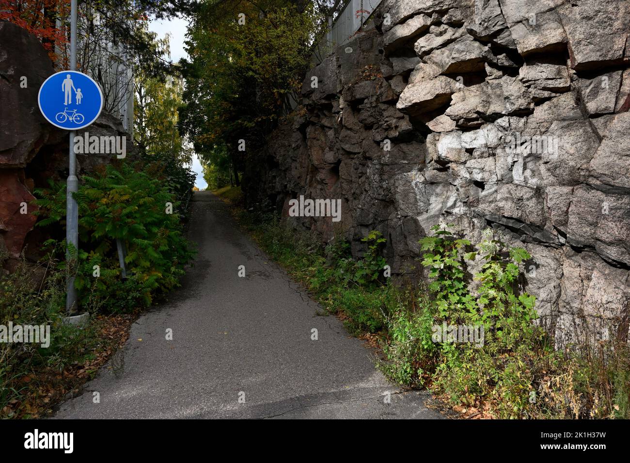walking and cycling path next to a rock in Finland Stock Photo