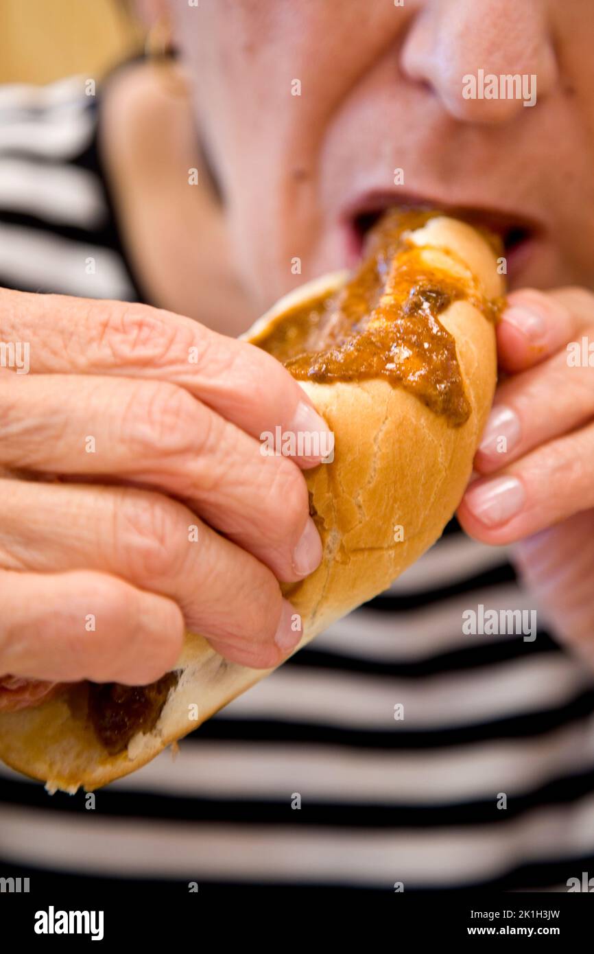 Woman eating a chili dog Stock Photo