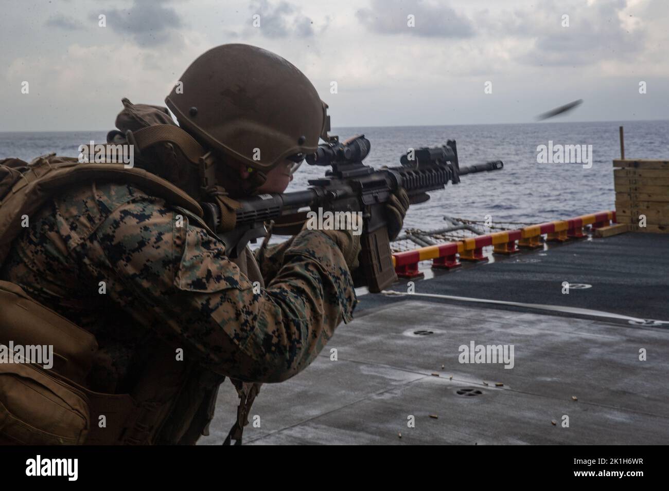 U.S. Marine Corps Lance Cpl. Austin Aguirre, a supply chain management specialist, with Battalion Landing Team 2/5, 31st Marine Expeditionary Unit, conducts shooting drills aboard Amphibious Assault Ship USS Tripoli (LHA-7), in the Philippine Sea, Sept. 14, 2022. The Marines conducted shooting drills to maintain their expertise in marksmanship. The 31st MEU is operating aboard ships of the Tripoli Amphibious Ready Group in the 7th Fleet area of operations to enhance interoperability with allies and partners and serve as a ready response force to defend peace and stability in the Indo-Pacific r Stock Photo